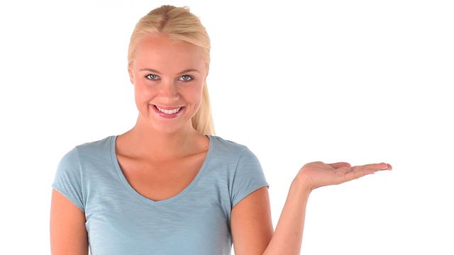 This image depicts a happy, smiling woman gesturing with her palm facing upwards against a plain white backdrop. Perfect for advertising concepts, customer service promotions, or adding a welcoming, approachable element to marketing and corporate presentations.