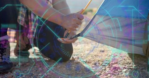 Hands securing tent equipment in rugged outdoor adventure scene