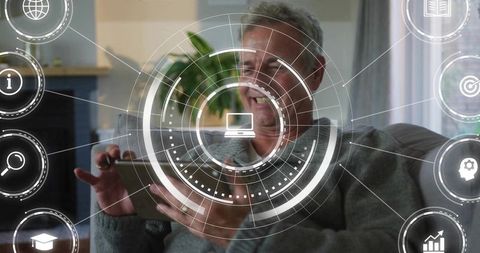 Smiling Senior Man Holding Tablet Using Futuristic Circular HUD Interface in Living Room