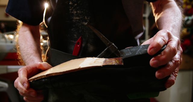 Mid-section of shoemaker repairing a shoe in workshop 4k