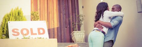 Happy Couple Celebrating New Home Purchase on Sunny Day