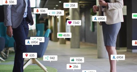 Professionals checking phones with social media badges in modern office corridor