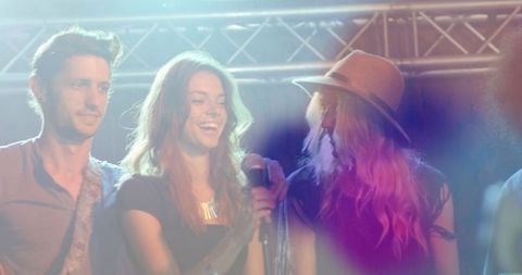 Happy band performing on stage amidst colorful lights