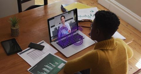 African american woman video conferencing on laptop home office setting
