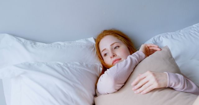 Thoughtful young woman lying in bed hugging pillow - Download Free Stock Images Pikwizard.com