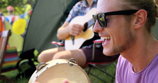 Young Man Playing Tambourine at Outdoor Music Festival - Download Free Stock Images Pikwizard.com