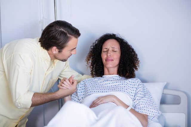 Man Comforting Pregnant Woman During Labor in Hospital Ward - Download Free Stock Photos Pikwizard.com