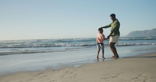 Happy african american father dancing with son on sunny beach - Download Free Stock Photos Pikwizard.com