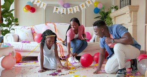 Family Enjoying Lively Birthday Celebration at Home with Confetti