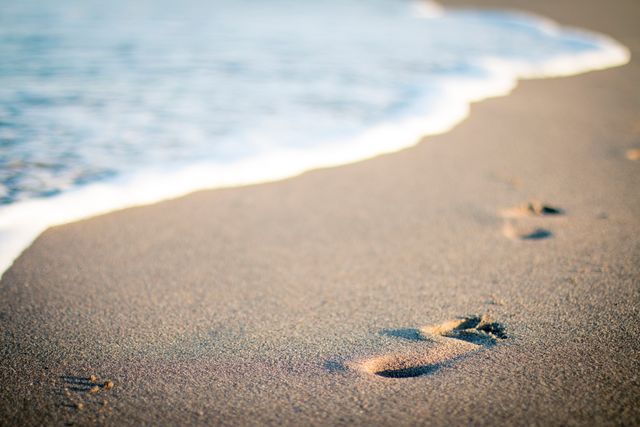Footprints in Sand near Gentle Ocean Wave - Download Free Stock Photos Pikwizard.com
