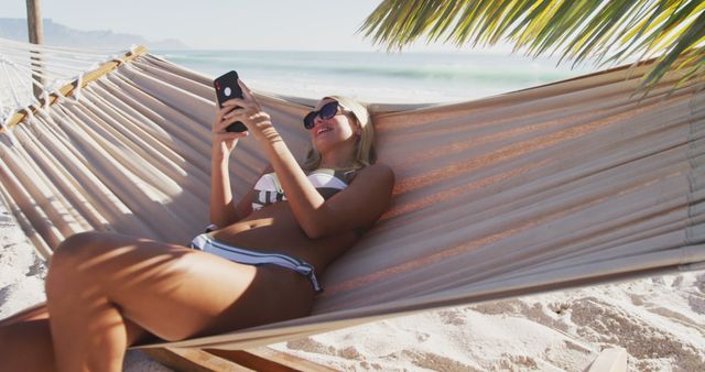 Woman Relaxing in Hammock at Tropical Beach while Using Smartphone - Download Free Stock Images Pikwizard.com