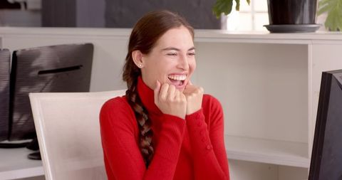 Enthusiastic Woman in Red Charming at Office Workspace