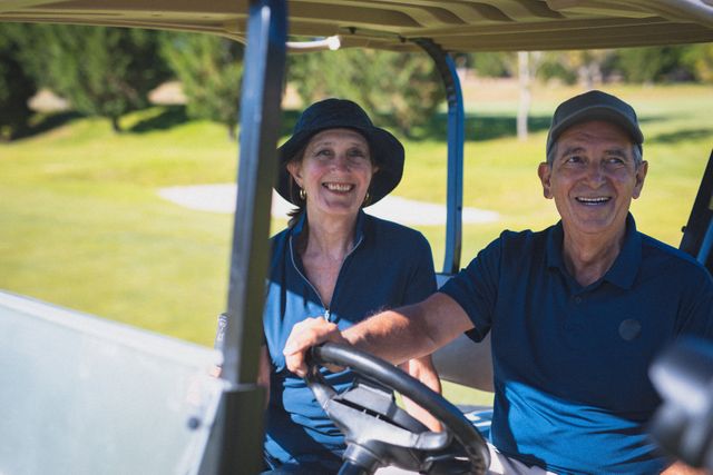 Happy caucasian senior couple driving in golf buggy at a golf course and smiling. golf sports hobby, healthy retirement lifestyle.