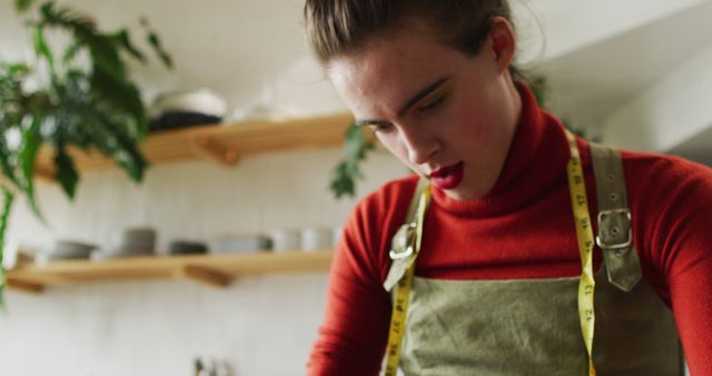 Caucasian non-binary transgender woman working at home, sewing. spending quality time at home alone, body inclusivity.