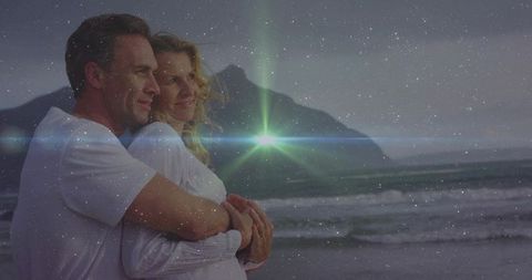Embracing Couple Gazing at Twilight Beach with Starburst Lens Flare and Mountain Ridge