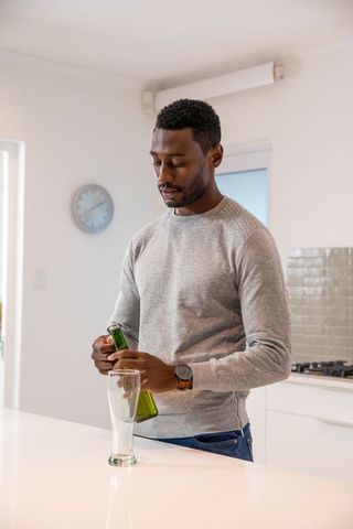 Man Pouring Beer in Minimalist Kitchen