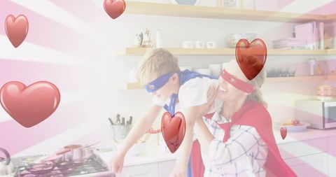 Joyful Mother and Son Playing in Kitchen with Superhero Capes