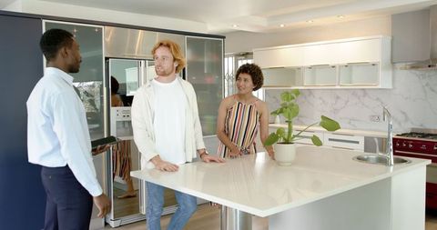 Real estate agent leading couple through modern home tour