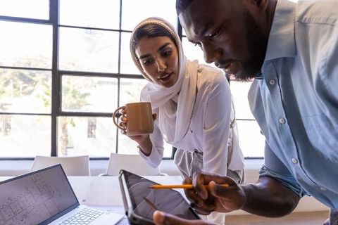Focused Coworkers Collaborating on Project with Digital Devices