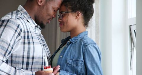 Couple Celebrating Anniversary at Home with Cupcake