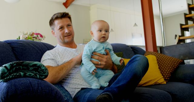 Father Holding Baby on Couch in Modern Living Room - Download Free Stock Images Pikwizard.com