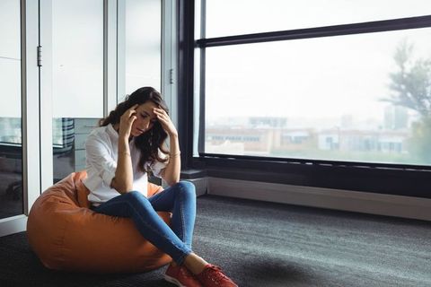 Stressed Woman Meditating in Modern Office Lounge