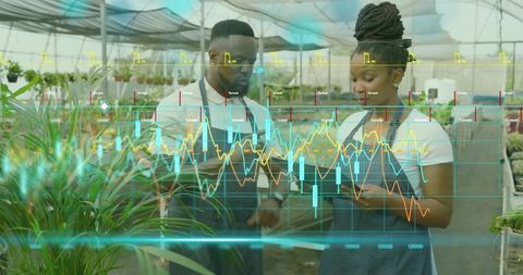 Nursery Staff Reviewing Tablet with Data Overlay in Greenhouse for Plant Care Analytics