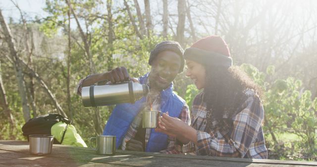 Couple Enjoying Hot Drink Outdoors in Sunlit Forest - Download Free Stock Images Pikwizard.com