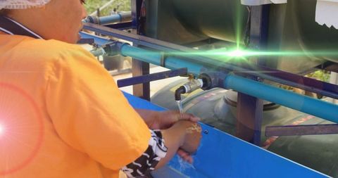 Woman washing hands outdoor at standpipe amidred digital lighting