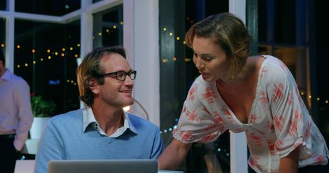 Collaborative Discussion with Laptop at Night in Modern Setting