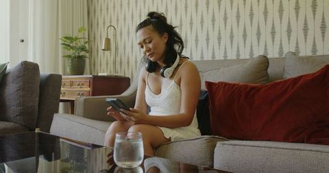 Woman Relaxing on Sofa with Smartphone