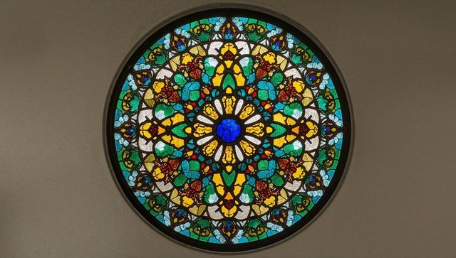 Intricate circular stained glass window with floral geometric design