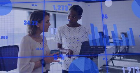 Businesswomen Collaborating Over Data Analytics in Modern Office