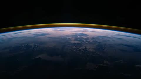 Orbiting Earth at Dawn Showing Curved Horizon with Colorful Atmospheric Airglow