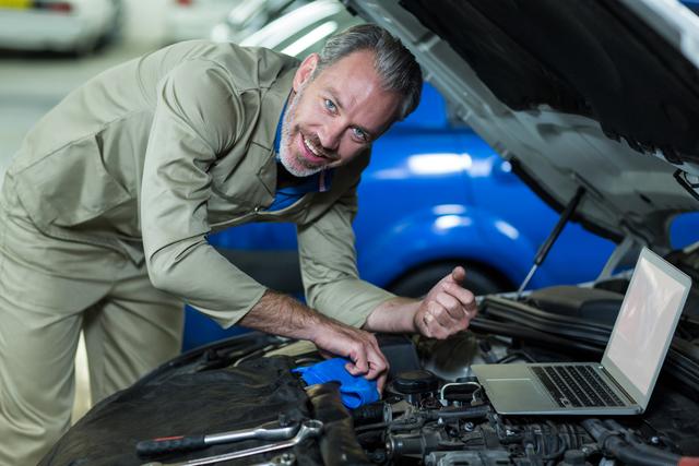 Mechanic servicing a automobile car engine in repair garage