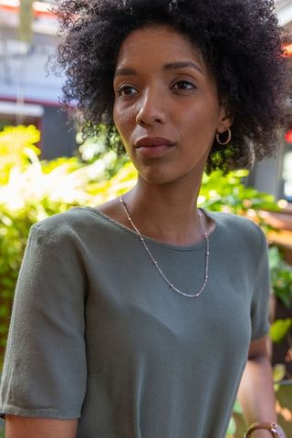 Woman in Greenhouse Cafe With Nature-Inspired Jewelry