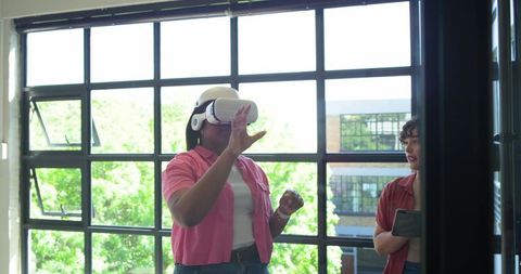 Female colleague exploring virtual reality headset during workplace training session