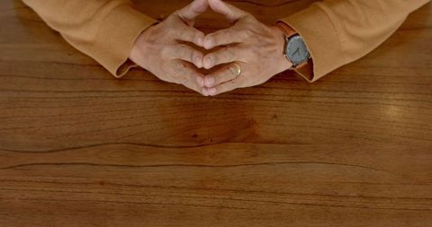 Hands Forming Gesture on Wooden Table Highlighting Communication Concept