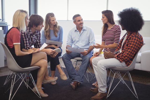 Mature manager conducting meeting with employees in creative office