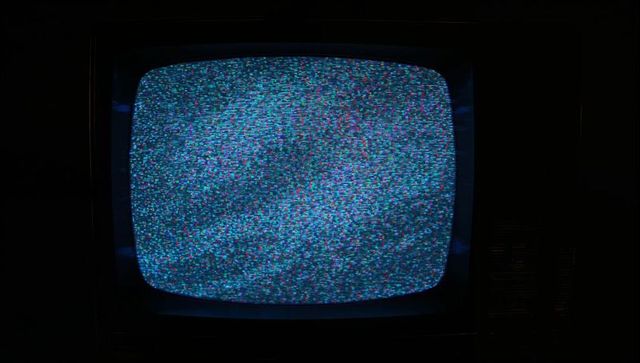 Vintage CRT Television Flickering with Blue-Green Static