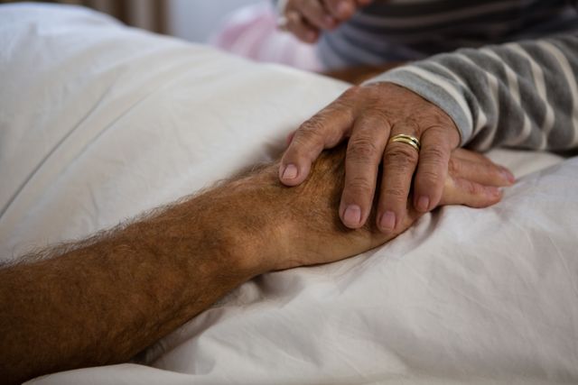 Senior couple holding hands, symbolizing love and support in a nursing home. Ideal for use in healthcare, elderly care, retirement living, and family support contexts.
