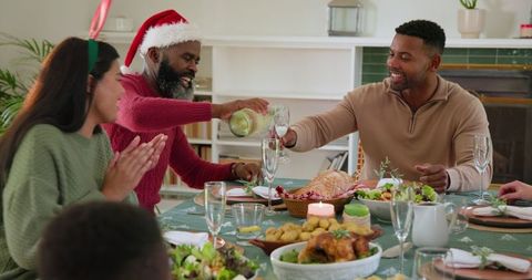 Diverse Family Enjoying Festive Meal with Christmas Spirits