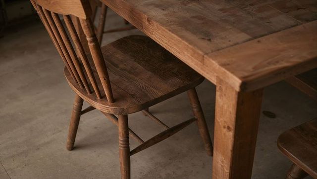 Spindle-back Farmhouse Chair Under Reclaimed Pine Table Showing Rich Wood Grain and Patina