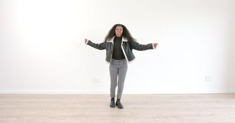 Joyful African American Woman Dancing in Stylish Jacket