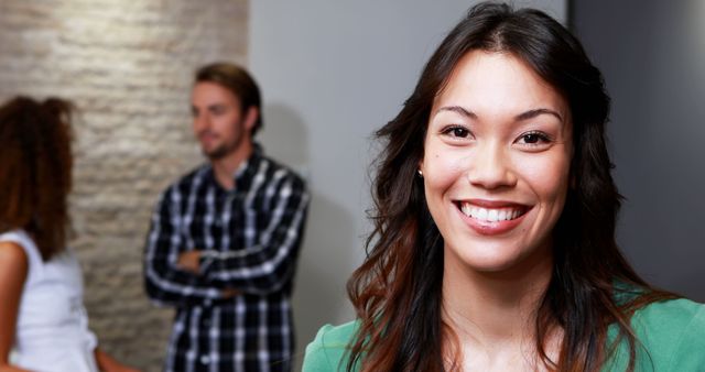 Smiling Woman with Colleagues in Background - Download Free Stock Images Pikwizard.com