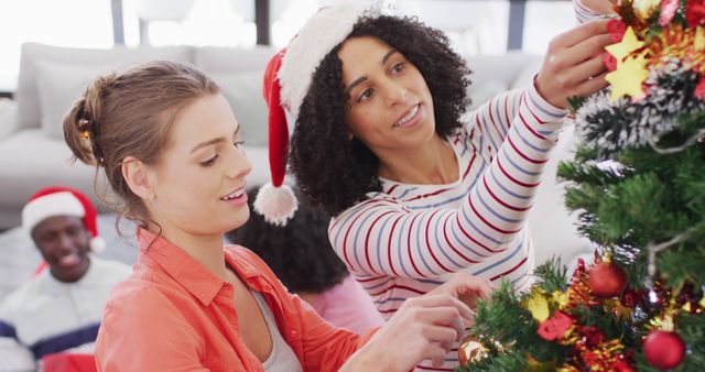 Two friends enthusiastically decorating a Christmas tree together, showcasing a joyful and collaborative holiday atmosphere. Bright and cheerful scene with holiday decorations and festive clothing, highlighting tradition and teamwork during winter celebrations. Use for promoting holiday togetherness, Christmas sales, festive events, or home decoration ideas.