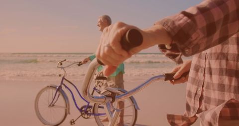 Senior Couple Biking Along Beach During Sunset