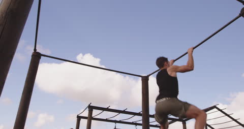 Man Performing Monkey Bars Exercise at Outdoor Bootcamp