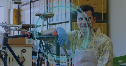 Bicycle mechanic leaning on repair stand wearing blue gloves and apron in workshop