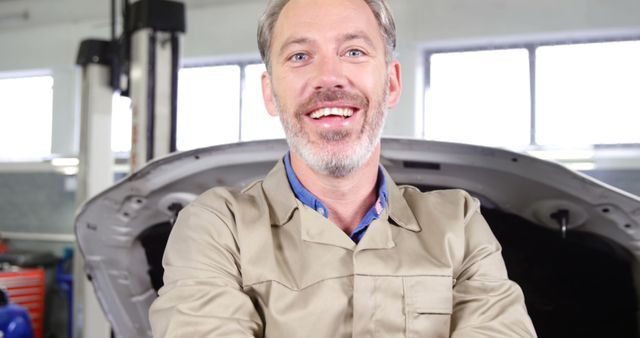 Senior Auto Mechanic Smiling at Service Garage with Open Hood in Background - Download Free Stock Images Pikwizard.com